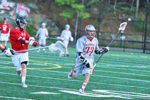 STEPHEN MARINO, a junior (#77), is pursued by Marblehead's P.J. Roy (#9) during last night's Div. 2 North semifinal game. Marino had a fine defensive game for the Warriors despite Wakefield's season coming to an end with a 13-6 loss at Landrigan Field. (Donna Larsson Photo)