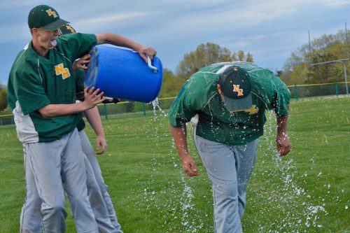 SPRING SHOWER. Senior Pitcher Gregory Johnson douses Coach Archambault with a victory shower following the Hornets' 5 to 2 win over the Triton Vikings that allowed them to clinch the Cape Ann League Large Championship. (Deanna Castro Photo)